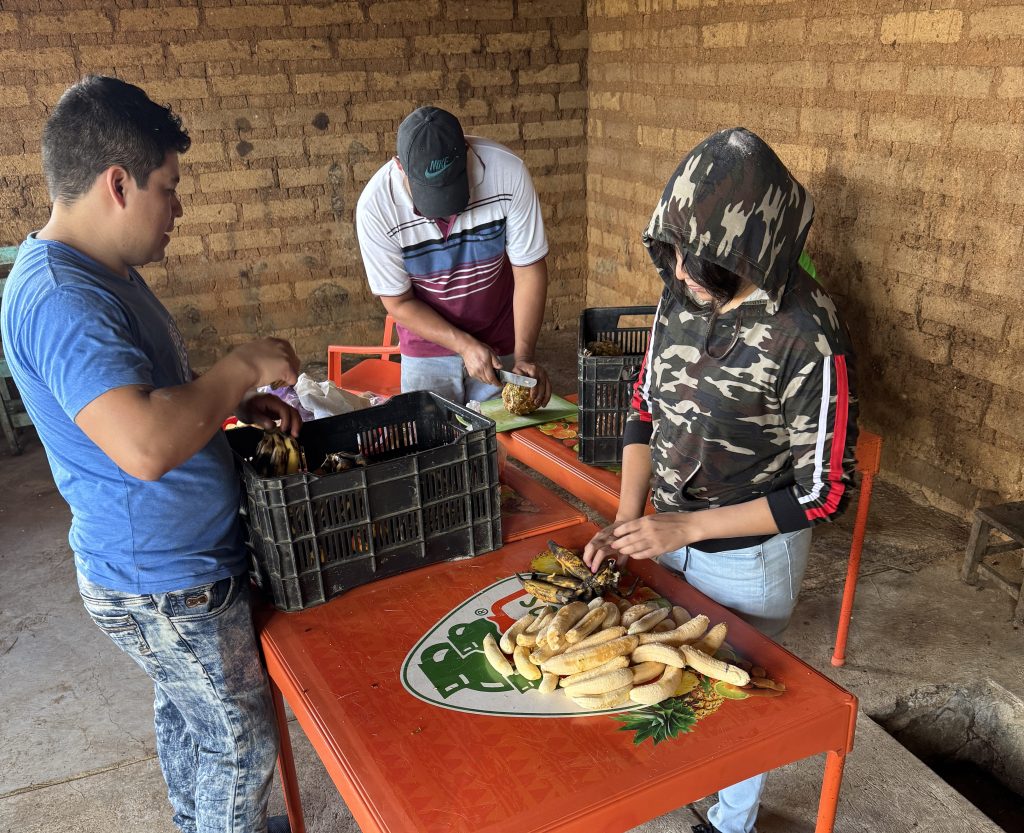 Workers prepare fresh, seasonal ingredients for the pechuga distillation.